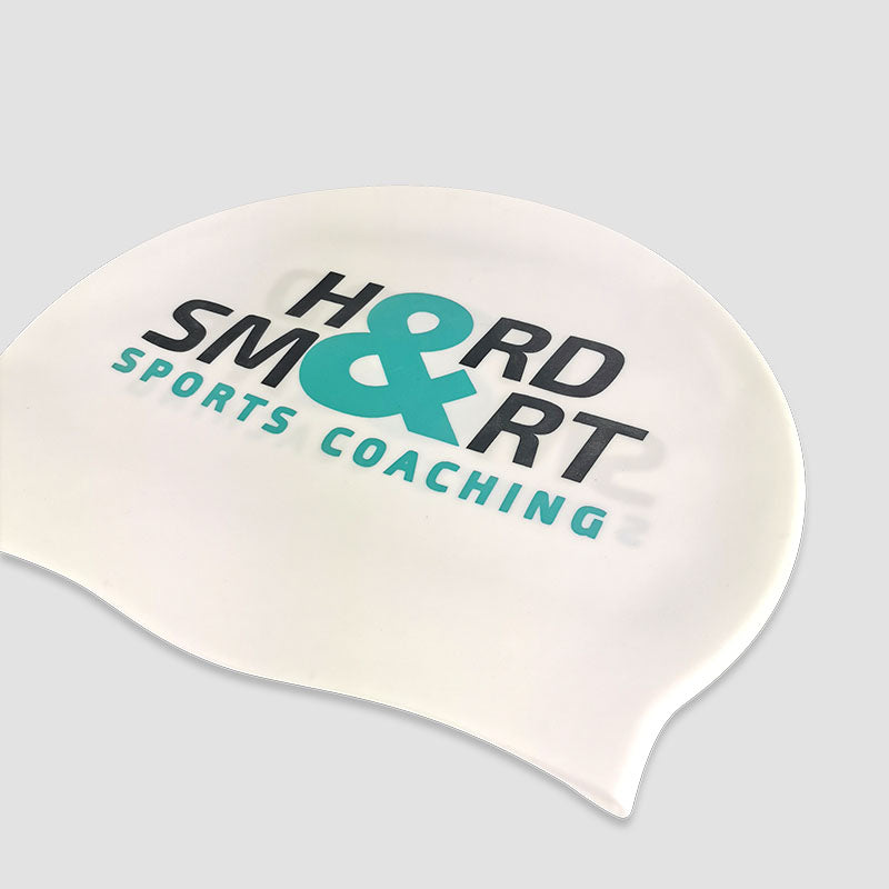 Close-up view of Hard & Smart Sports Coaching swimming cap in white